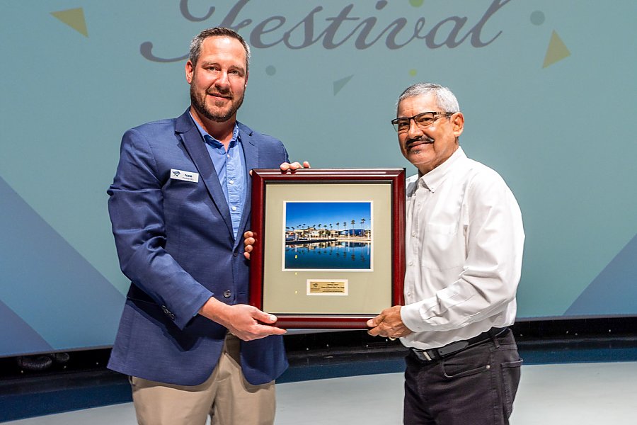 Two men holding a framed picture