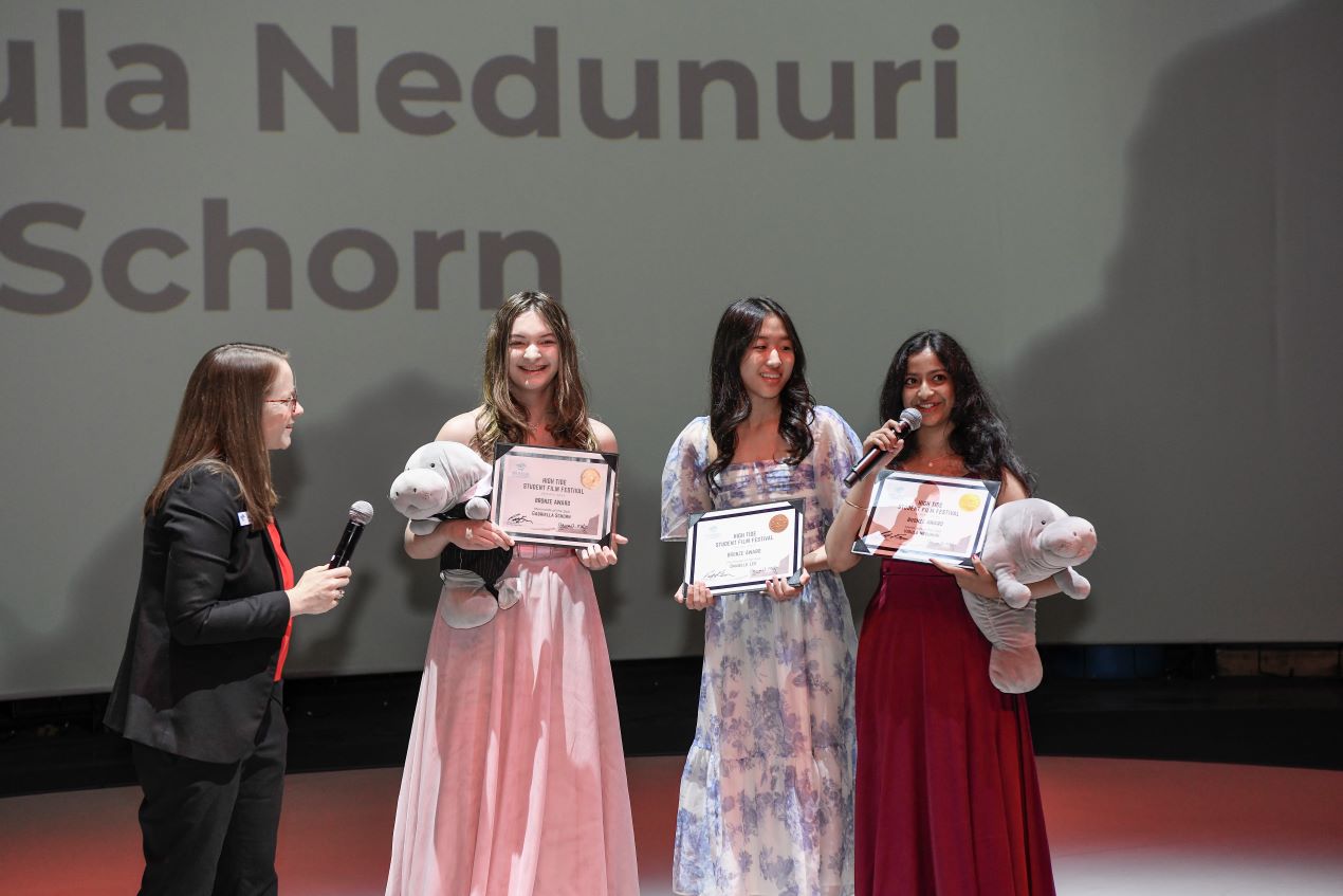 four people standing side by side smiling